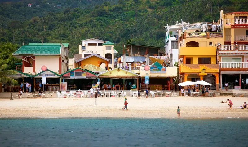 Plage avec bâtiments colorés et quelques personnes se relaxant au soleil