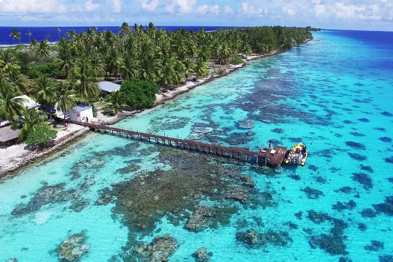 Vue aérienne d'un ponton en bois sur un lagon turquoise peu profond