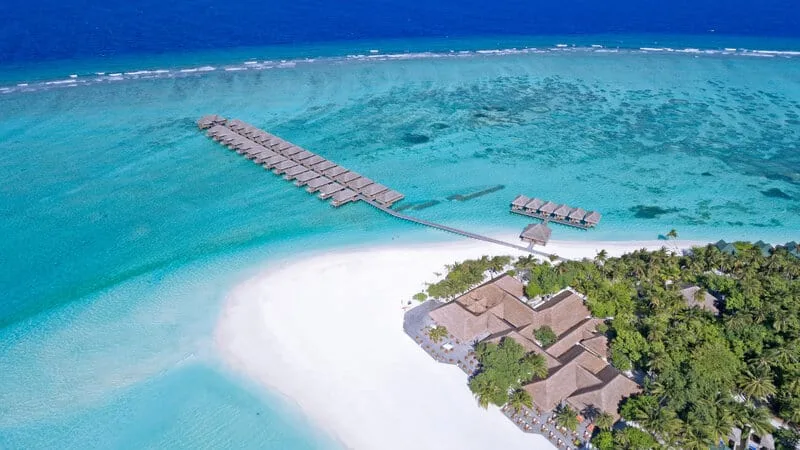 Vue aérienne d'une plage tropicale avec des bungalows sur pilotis