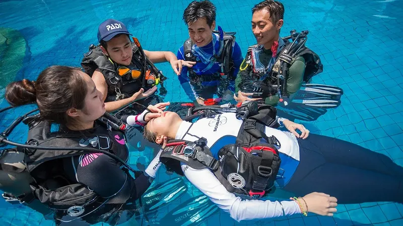 Quatre personnes équipées pour la plongée, une en surface, les autres aident