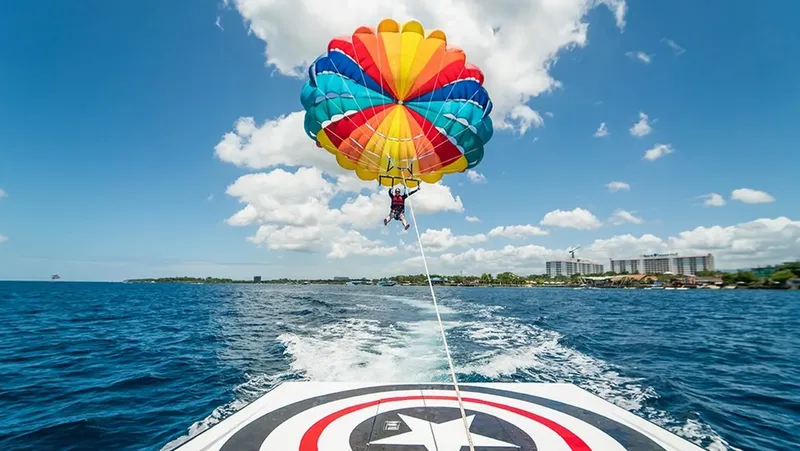 Personne en parachute ascensionnel tirée par un bateau rapide en mer