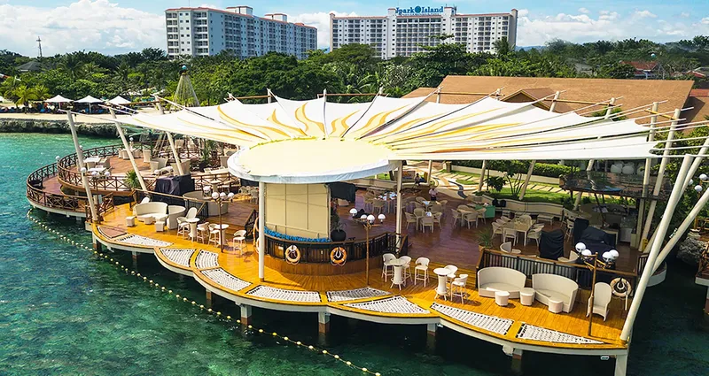 Terrasse en bois sur l'eau avec parasols et mobilier de jardin