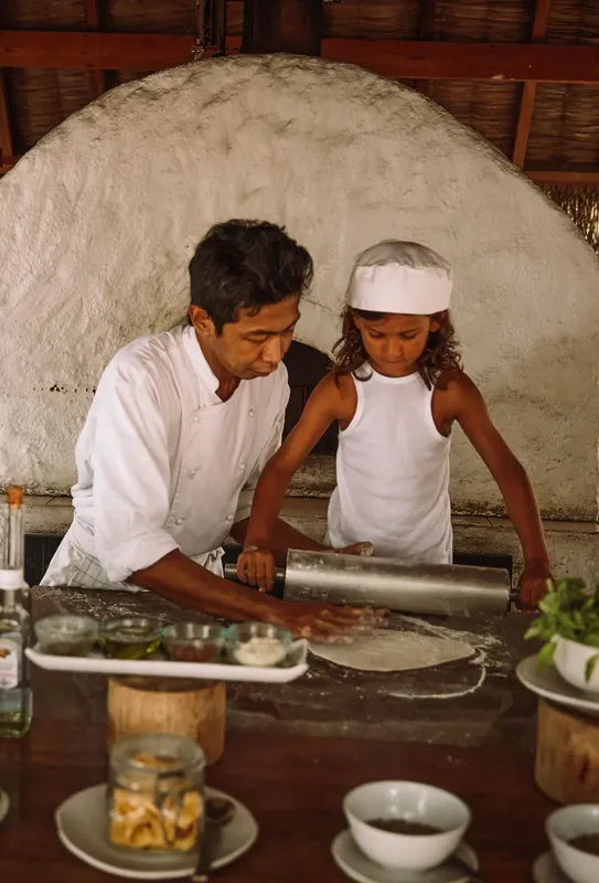 Un homme et une enfant préparent de la pâte à pizza ensemble