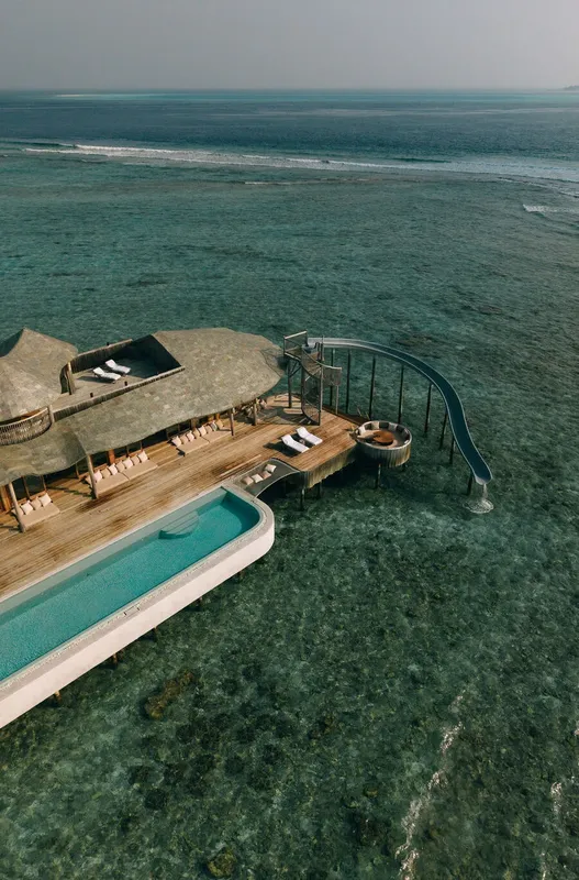 Plateforme en bois avec piscine, toboggan et espaces de détente en mer