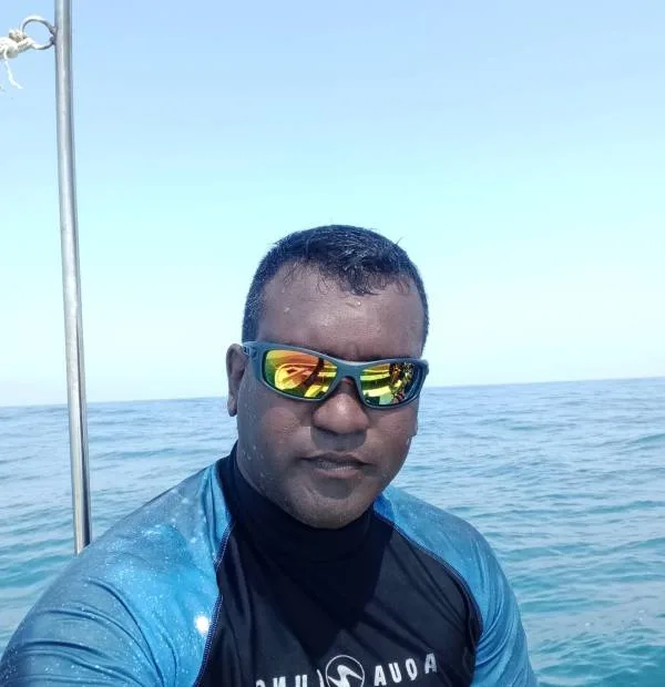 Homme portant des lunettes de soleil sur un bateau en mer
