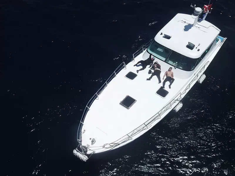 Bateau de plongée blanc avec des personnes bronzant au soleil en mer