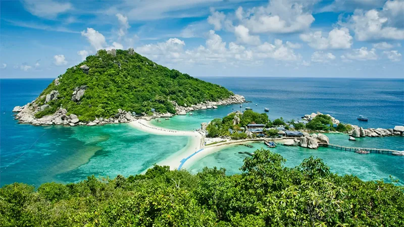 Île tropicale avec plage de sable blanc et bateaux amarrés