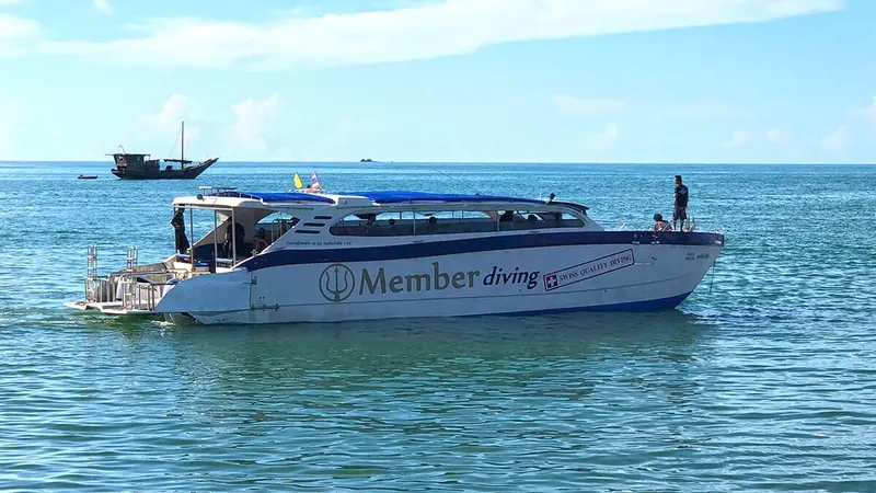 Bateau de plongée blanc et bleu sur une mer calme ensoleillée