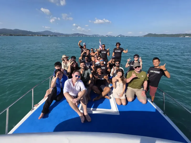 Groupe de personnes souriantes sur le pont d'un bateau en mer