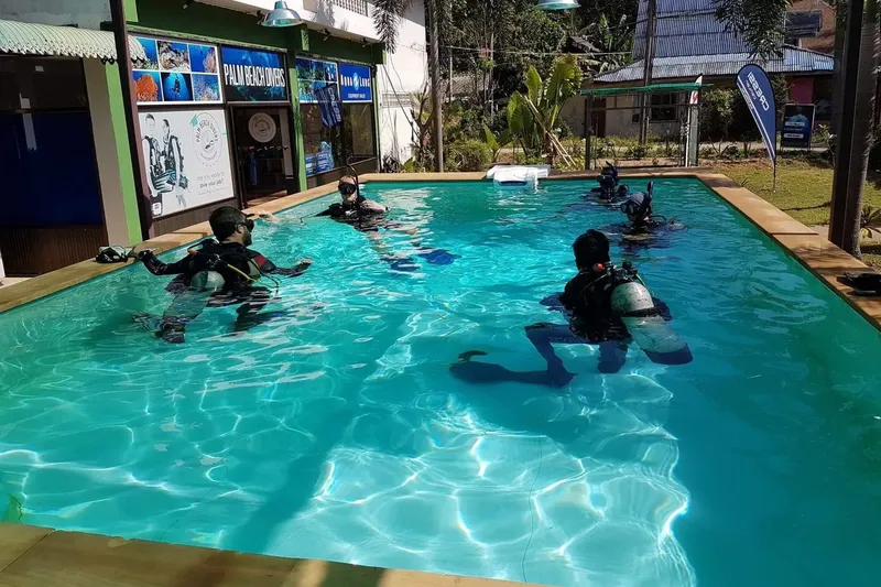 Des plongeurs s'entrainent en piscine avec leur équipement complet