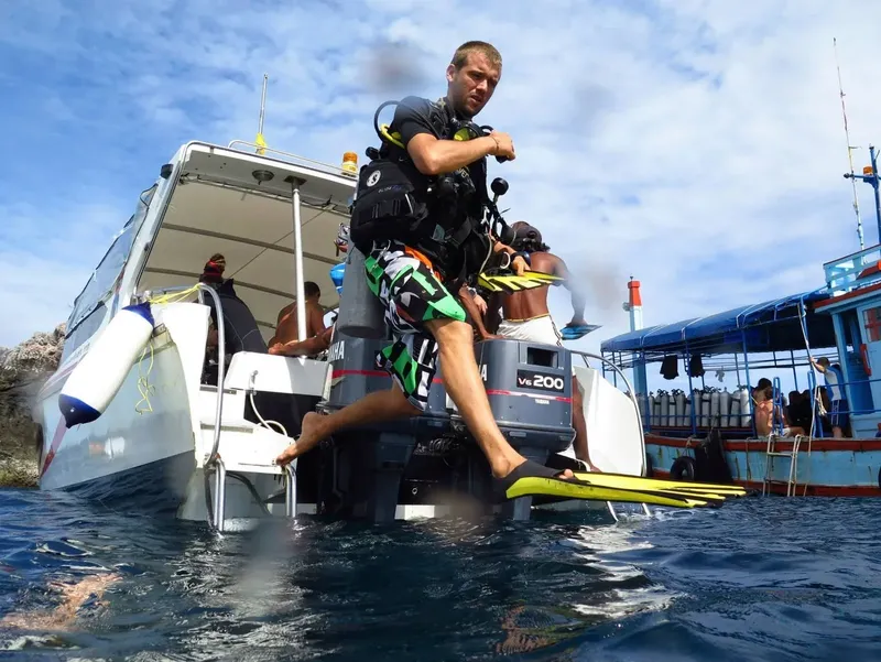 Plongeur s'apprête à entrer dans l'eau depuis un bateau de plongée