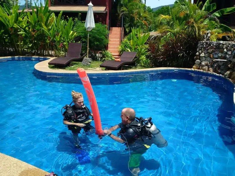 Deux plongeurs en formation dans une piscine avec équipement complet
