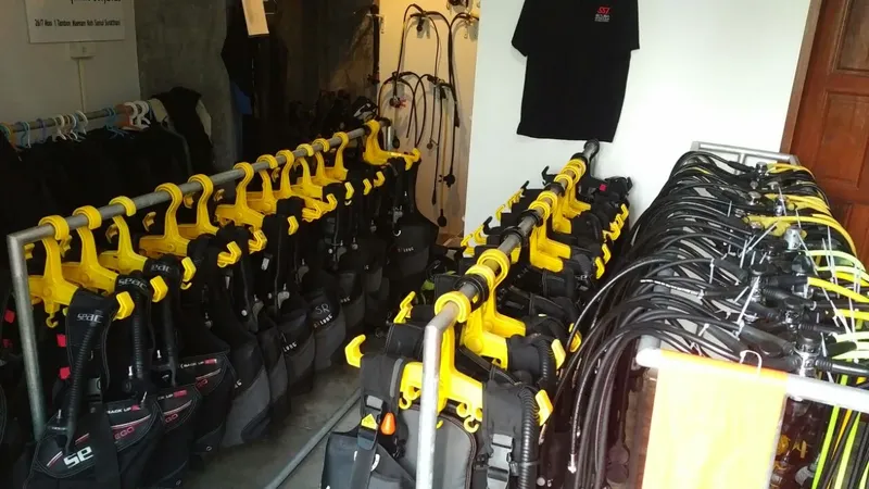 Rangées de bouteilles de plongée avec détendeurs et gilets noirs et jaunes
