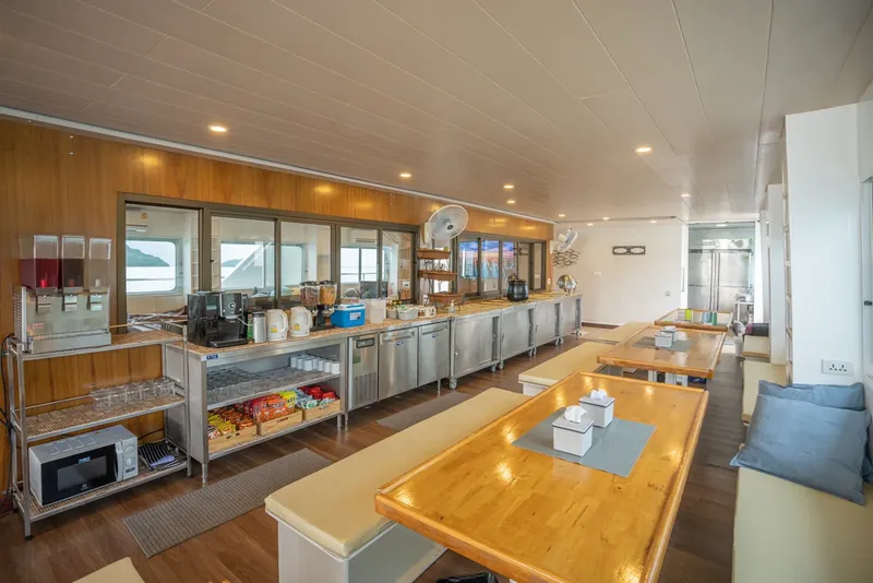 Intérieur d'un bateau de plongée avec coin repas et kitchenette lumineuse