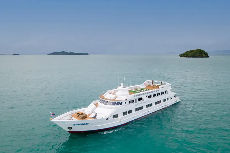 Grand bateau de croisière blanc et bleu navigue sur mer turquoise