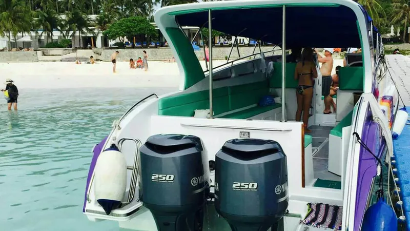 Bateau de plongée amarré sur une plage tropicale avec des passagers