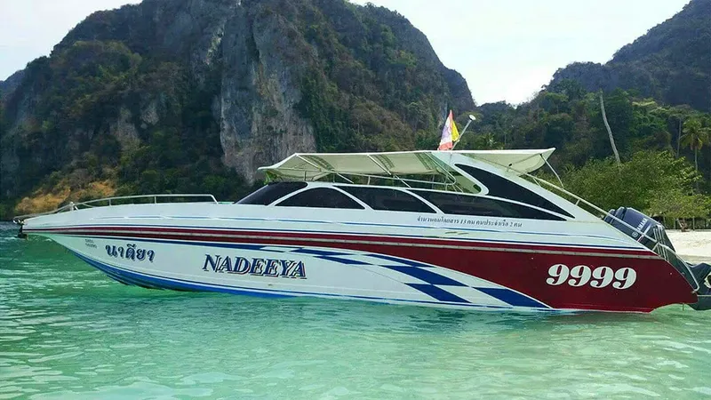 Bateau rapide bleu et rouge amarré dans une baie tropicale