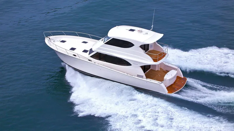 Yacht blanc naviguant sur une mer bleue avec une trace blanche