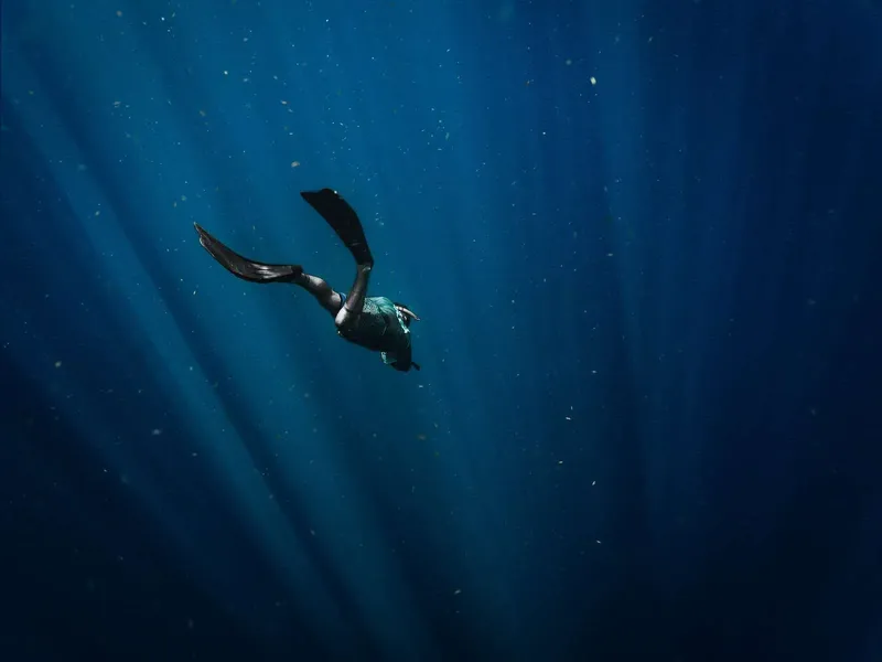 Apnea, nageur en apnée évoluant dans une eau bleue et lumineuse