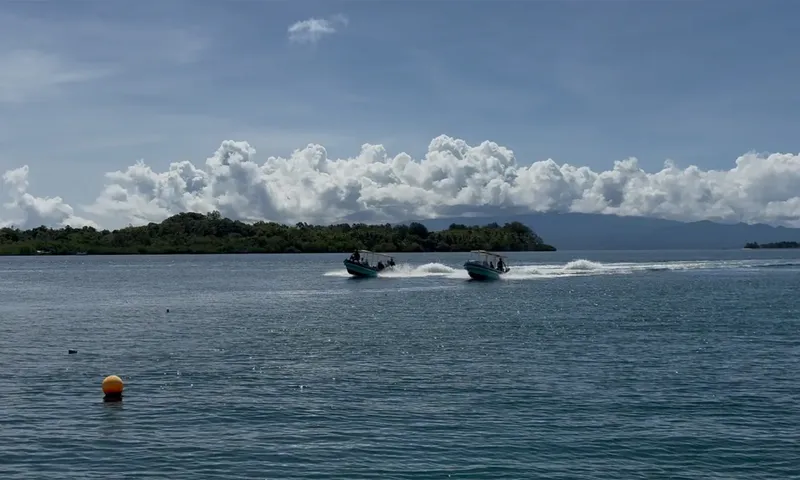 Deux bateaux de plongée naviguent sur une mer calme et bleue