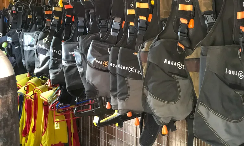 Rangée de gilets de sauvetage noirs et oranges suspendus au centre