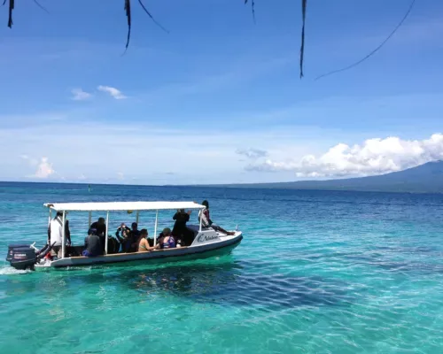 Embarcation avec plusieurs personnes à bord sur une mer turquoise