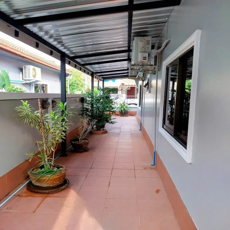 Couloir extérieur couvert avec des plantes en pot et des climatiseurs