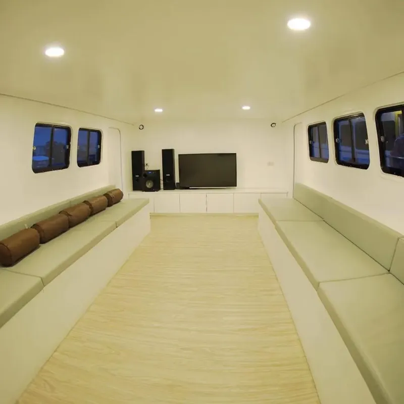 Intérieur clair d'un bateau de plongée avec banquettes et écran