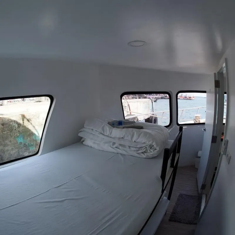Intérieur d'un bateau de plongée avec des couchettes et hublots ouverts