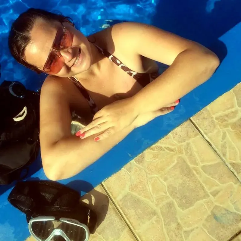 Femme souriante au bord d'une piscine avec masque et tuba