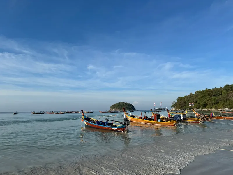 Plage avec plusieurs bateaux de pêche traditionnels échoués sur le sable