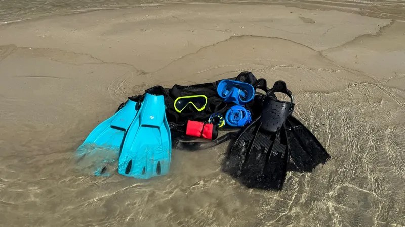 Equipement de plongée : palmes, masque, tuba, gilet sur sable mouillé