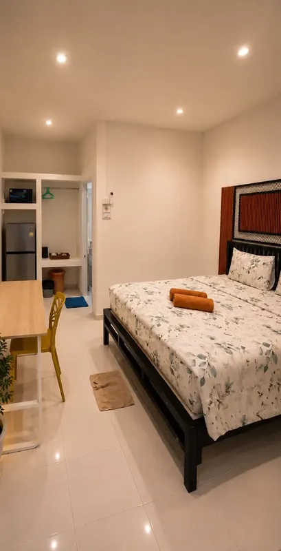Chambre d'hôtel simple avec un lit, un bureau et un réfrigérateur