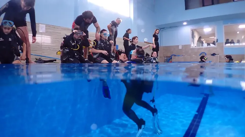 Plongeurs en formation dans une piscine, instructeurs et équipement visible