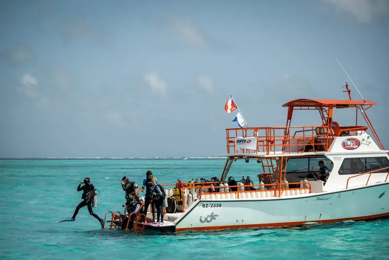Plongeurs s'équipent sur un bateau de plongée en mer turquoise