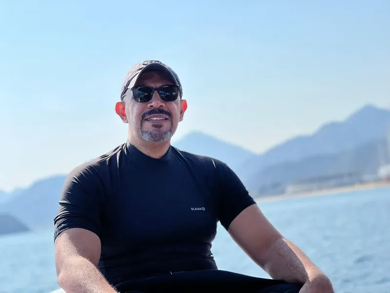 Homme souriant portant une combinaison de plongée sur un bateau en mer