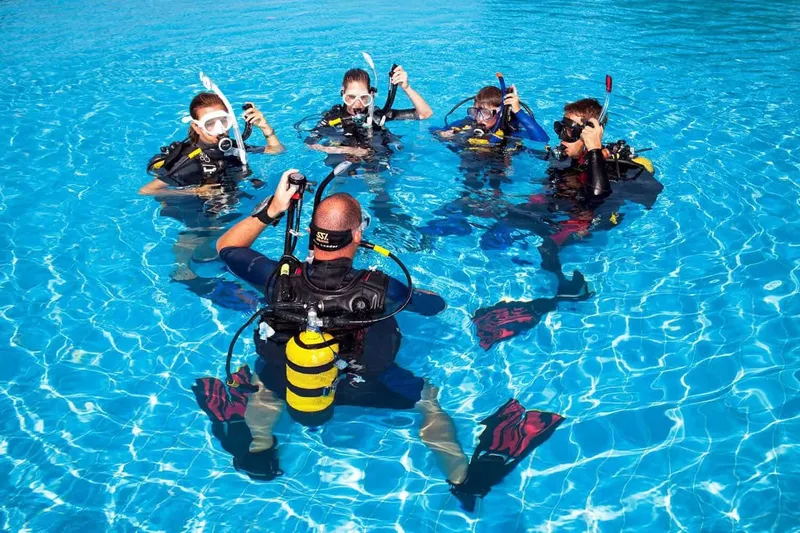 Groupe de plongeurs en formation dans une piscine bleu clair