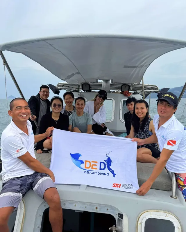 Groupe de plongeurs souriants sur un bateau en mer