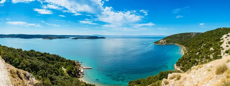 Vue panoramique d'une côte rocheuse avec mer bleue et quelques bateaux