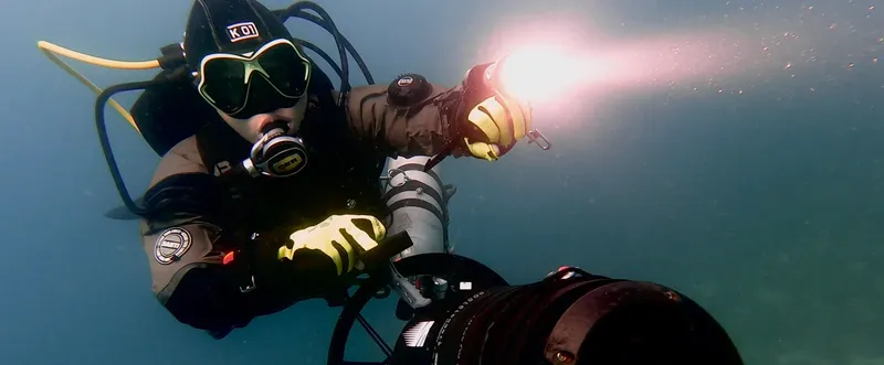 Plongeur avec équipement complet et lampe sous-marine en exploration