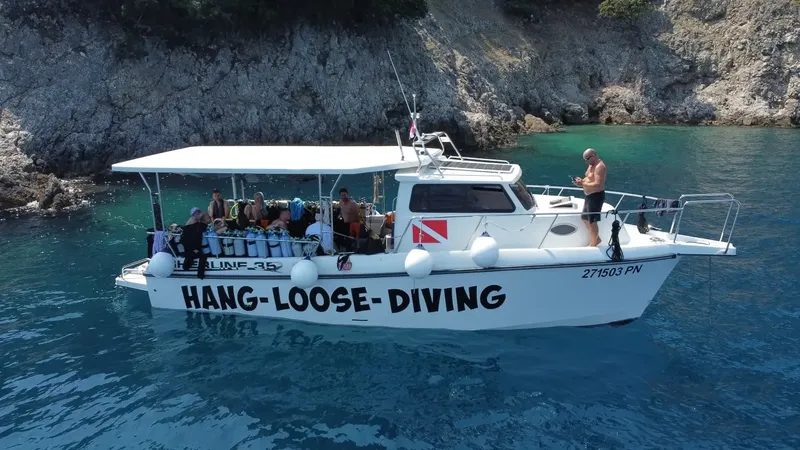 Bateau de plongée blanc avec des plongeurs et l'inscription Hang Loose Diving