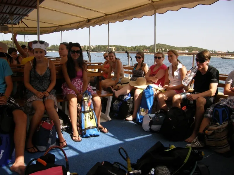 Groupe de personnes assises sur un bateau avec du matériel de plongée
