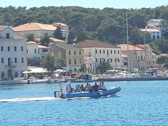 Un bateau semi-rigide navigue avec des passagers à bord en mer