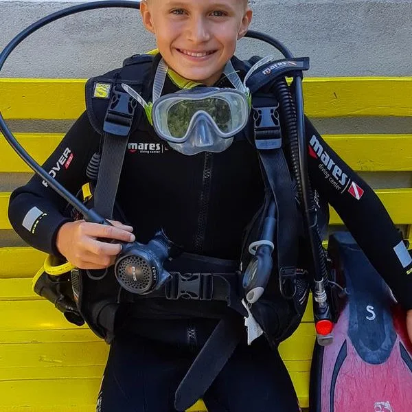 Jeune plongeur souriant équipé d'un gilet et d'un masque complet