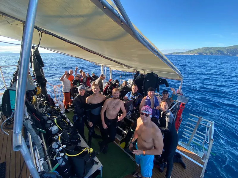 Groupe de plongeurs souriants sur le pont d'un bateau en mer