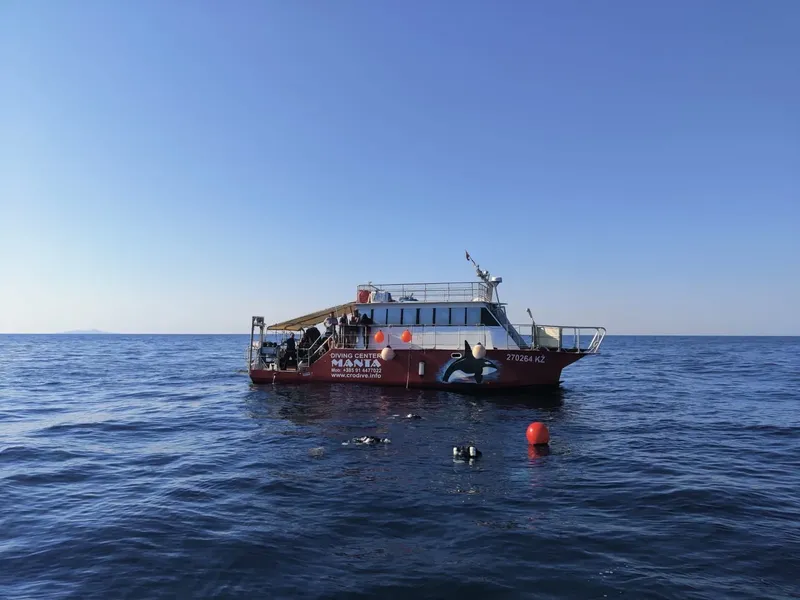 Bateau de plongée rouge en mer avec des personnes à bord