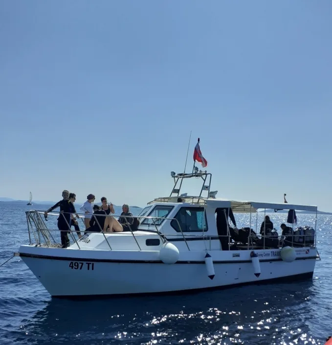 Plongeurs sur un bateau blanc en mer, préparation à une immersion