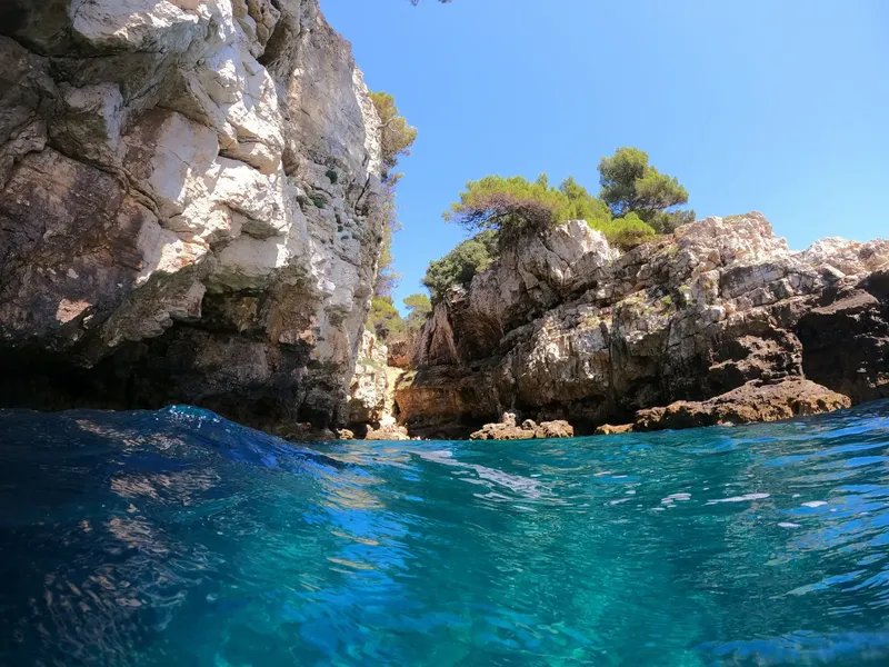 Vue sous-marine d'une falaise rocheuse et d'une crique ensoleillée