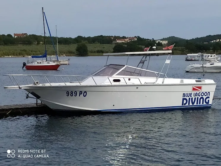 Bateau de plongée amarré au ponton avec logo et numéro d'immatriculation