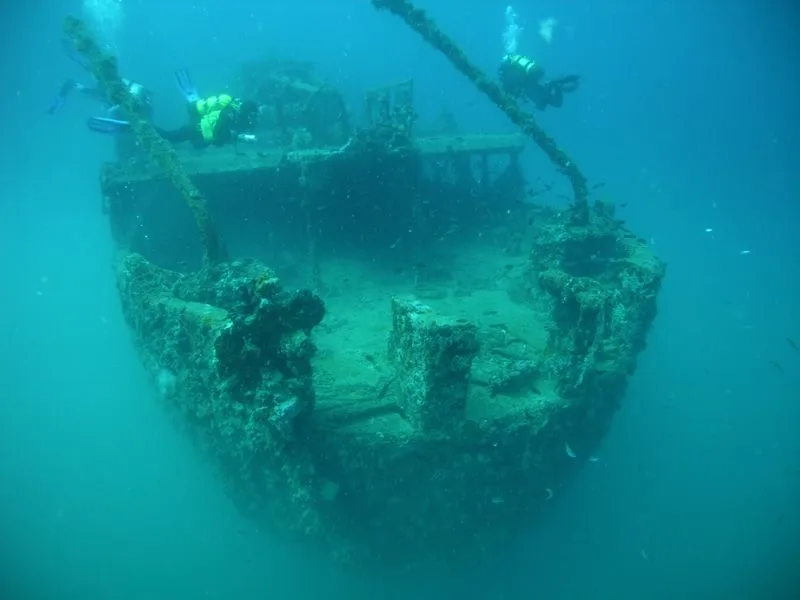 Deux plongeurs explorent l'épave d'un bateau coulé en mer